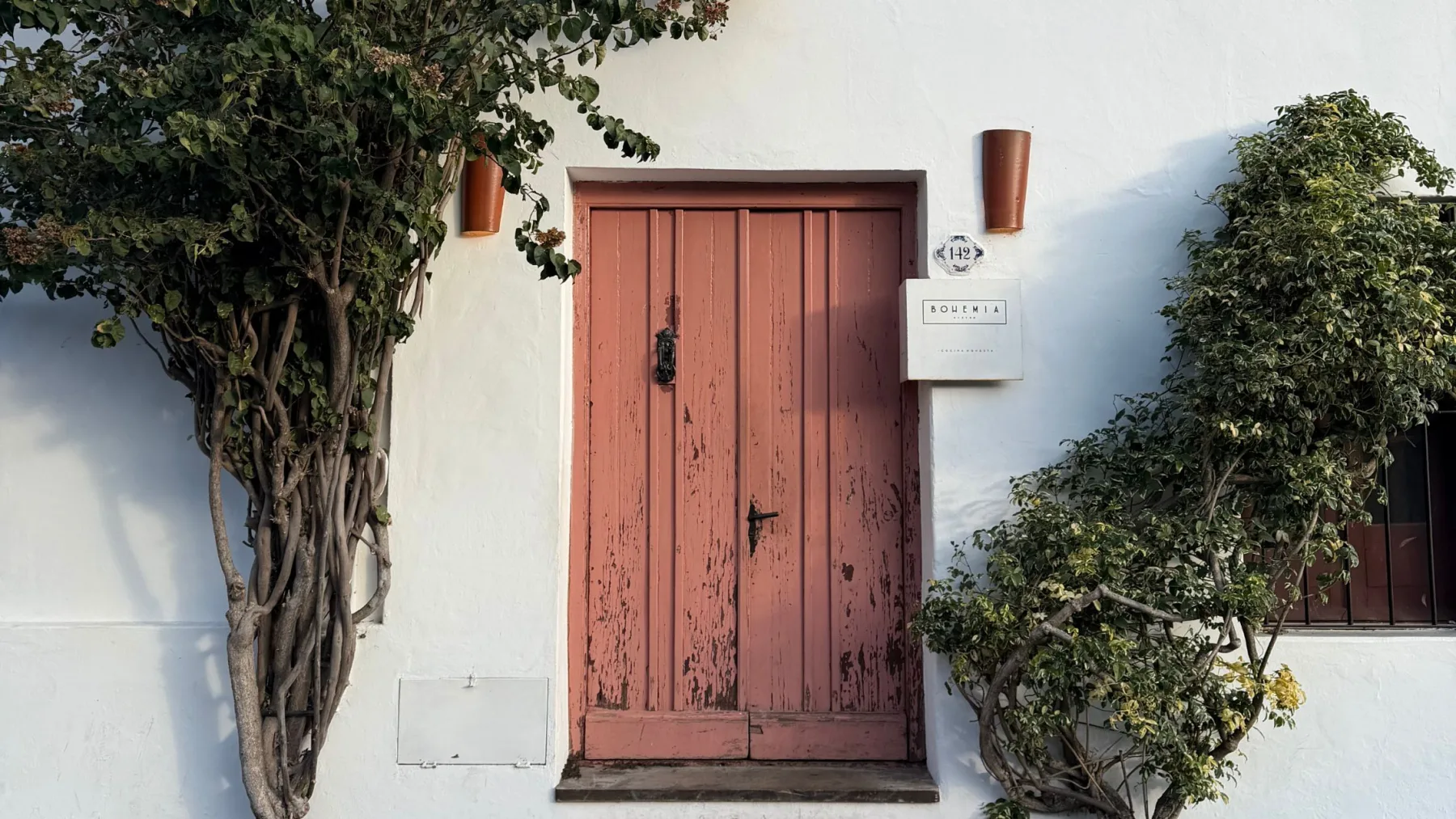 Porta de madeira rosada na fachada do restaurante Bohemia Bistró, no Bairro Histórico de Colonia del Sacramento, Uruguai.