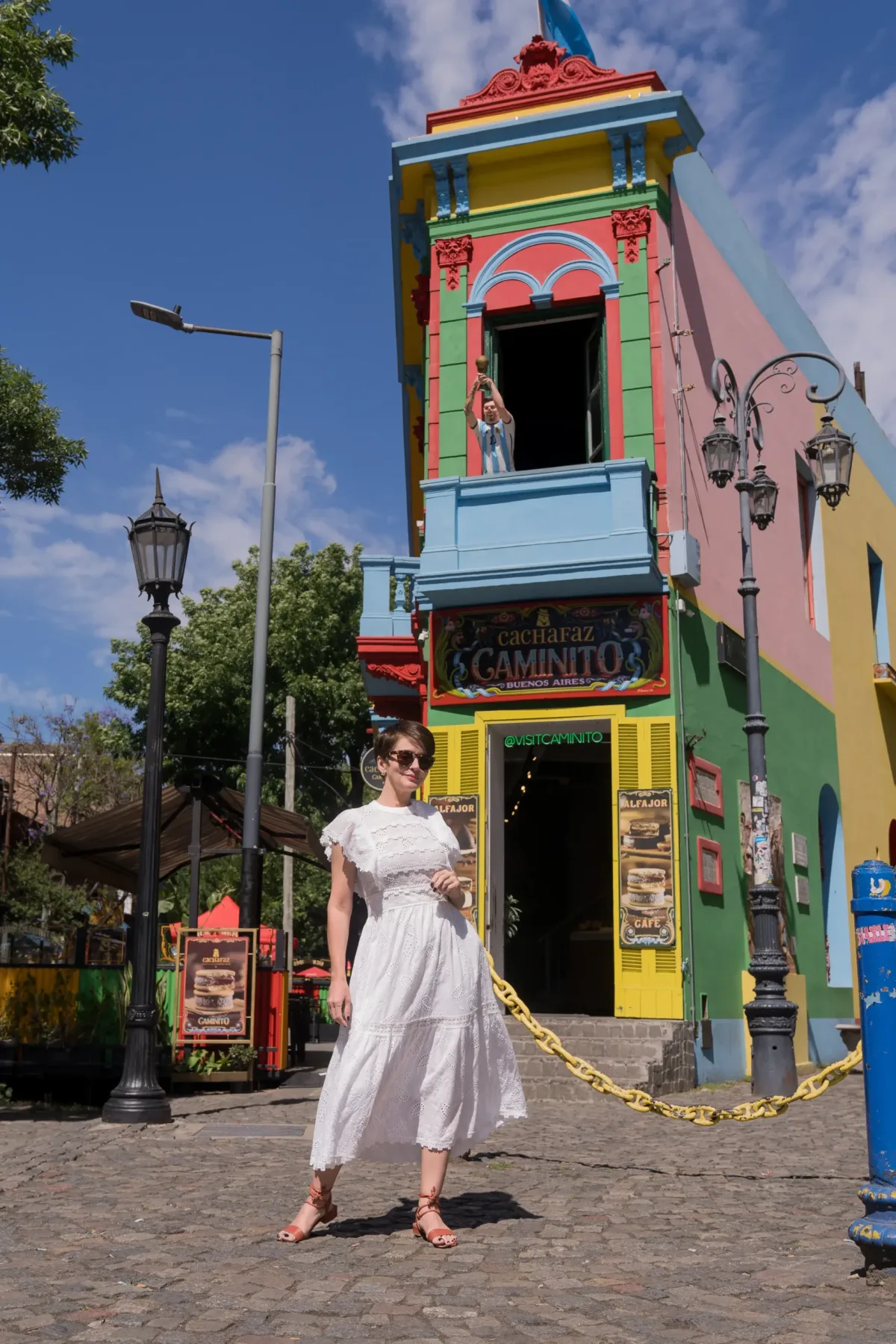 Mulher em frente a uma porta colorida no Caminito