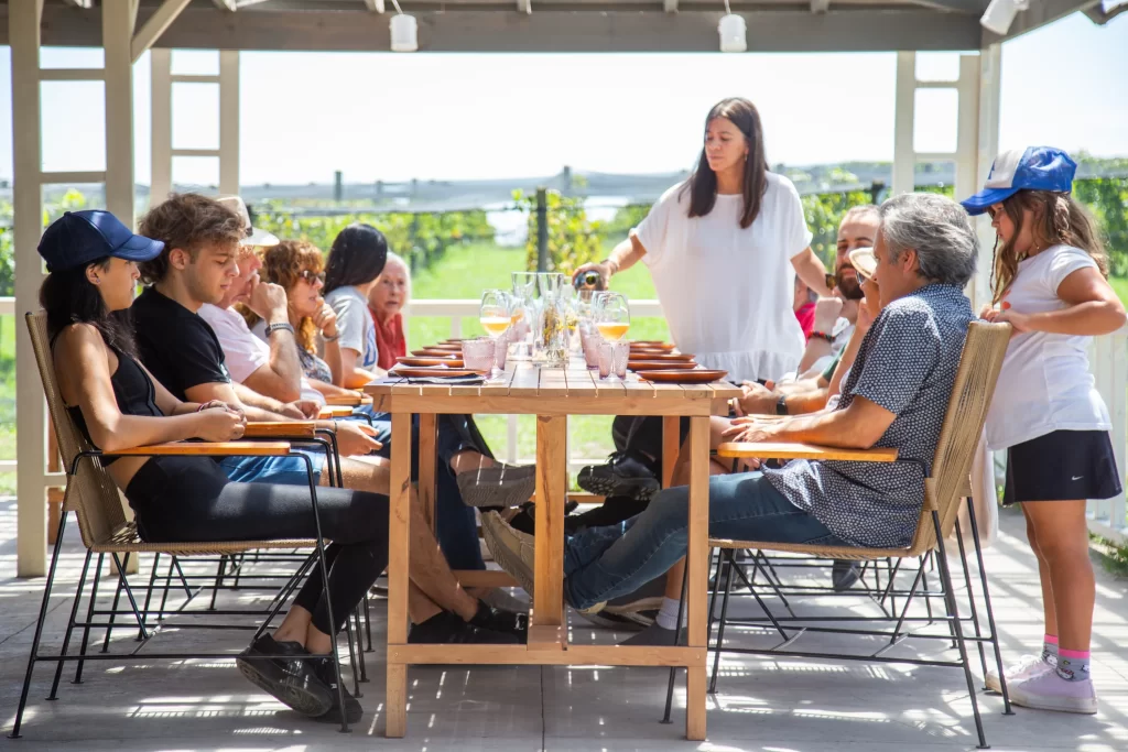 Grupo de pessoas sentado à mesa, desfrutando de um almoço harmonizado com vinhos exclusivos da Bodega Gamboa.